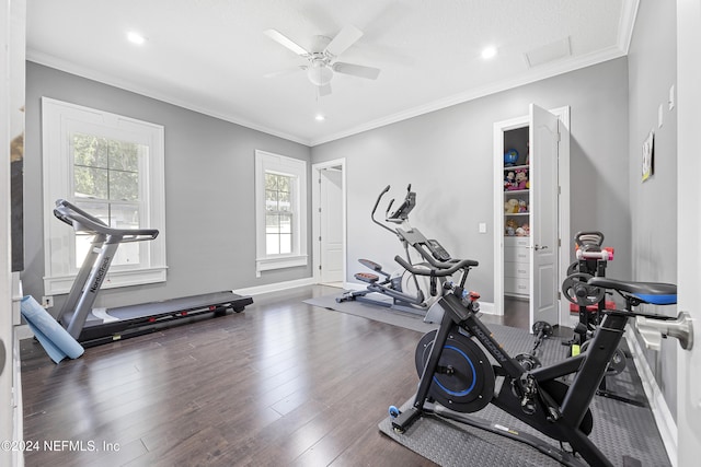 workout area featuring dark wood-style floors, crown molding, and baseboards