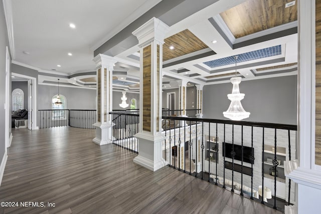 hall with decorative columns, coffered ceiling, ornamental molding, dark wood-style flooring, and an upstairs landing