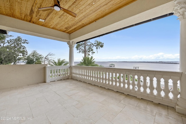 view of patio with a water view, ceiling fan, and a balcony