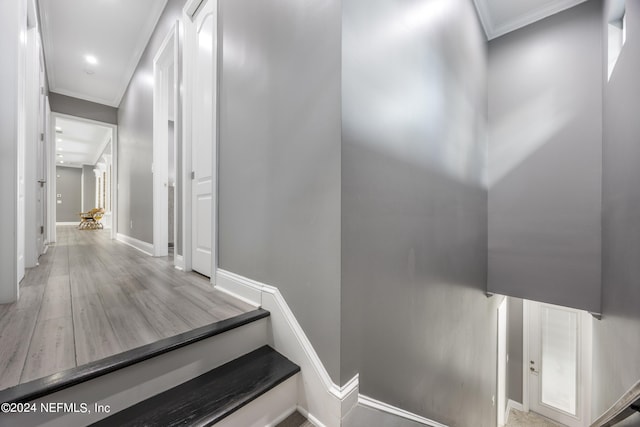 stairway featuring ornamental molding, baseboards, and wood finished floors