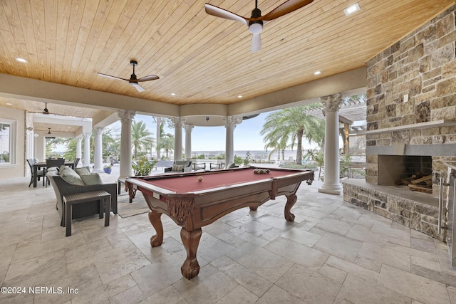 rec room featuring ceiling fan, stone tile floors, wood ceiling, and ornate columns