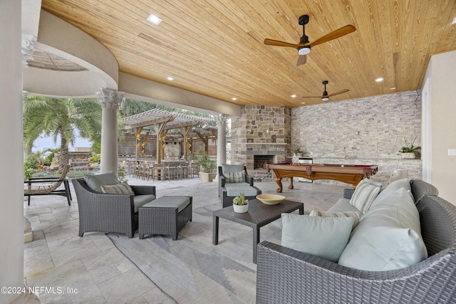 view of patio / terrace with an outdoor living space with a fireplace and a ceiling fan