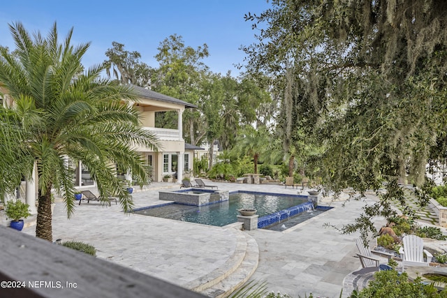 view of swimming pool featuring a pool with connected hot tub and a patio area