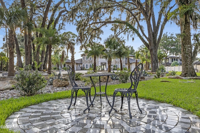 view of community featuring a lawn, a patio area, and a residential view