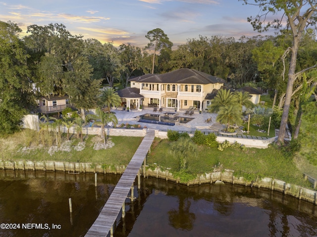 rear view of property featuring a water view, a patio area, a balcony, and a gazebo