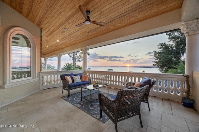 view of patio with a water view, ceiling fan, and outdoor lounge area