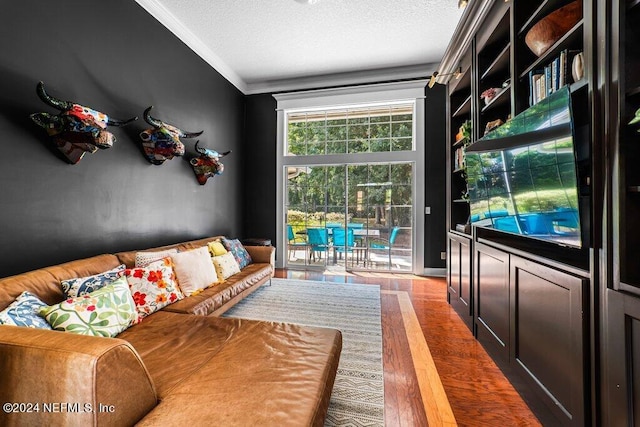 interior space featuring ornamental molding, hardwood / wood-style flooring, and a textured ceiling