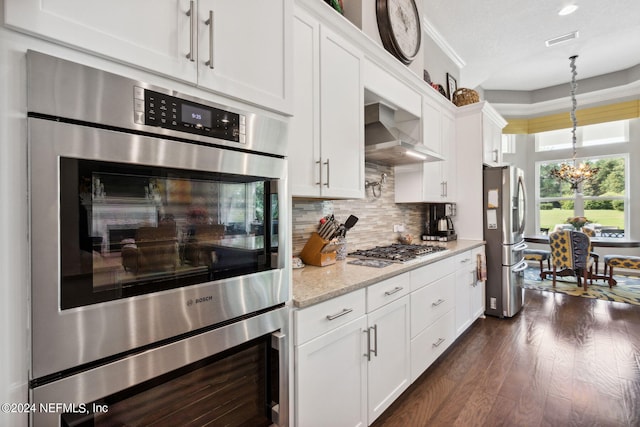 kitchen featuring backsplash, stainless steel appliances, decorative light fixtures, white cabinets, and dark wood-type flooring