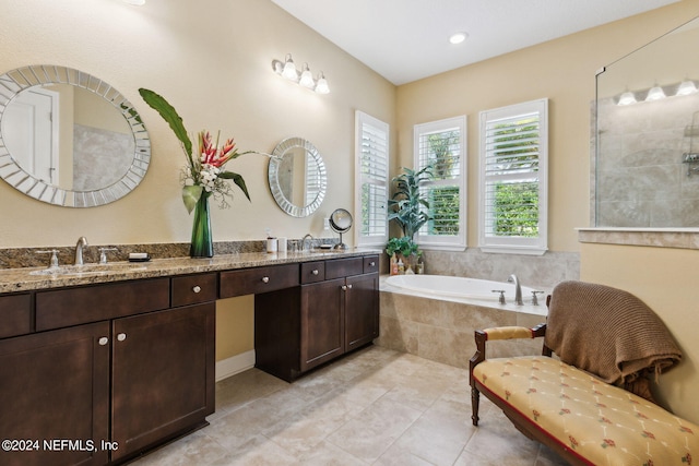 bathroom featuring tile patterned floors, double vanity, and tiled bath