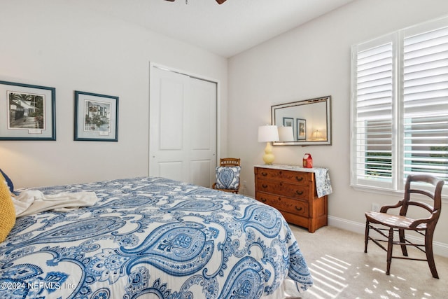 carpeted bedroom featuring ceiling fan and a closet