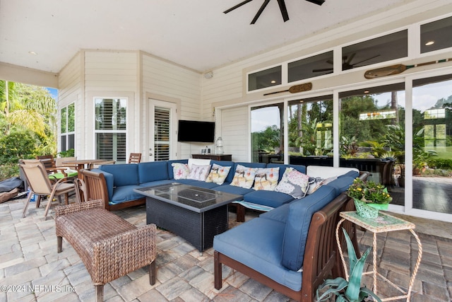 view of patio / terrace featuring ceiling fan and an outdoor living space with a fire pit