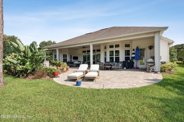 rear view of house featuring ceiling fan, a patio area, and a yard