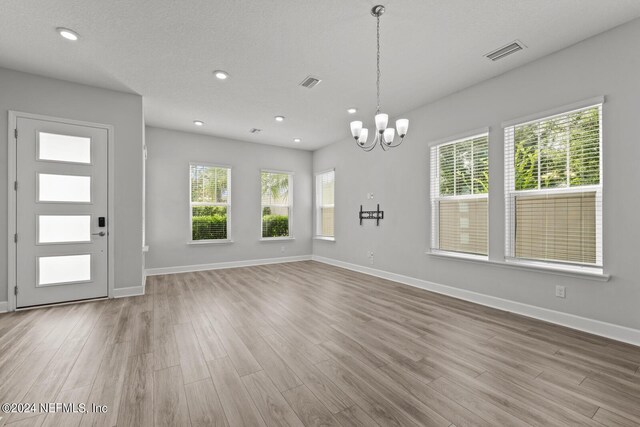 interior space featuring light hardwood / wood-style floors, a notable chandelier, and a healthy amount of sunlight