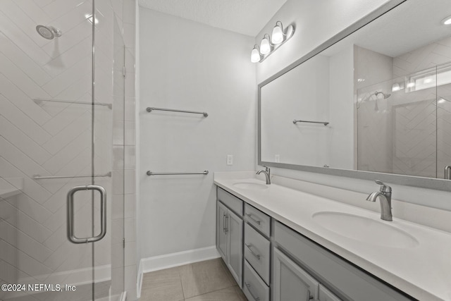 bathroom with a textured ceiling, an enclosed shower, and vanity