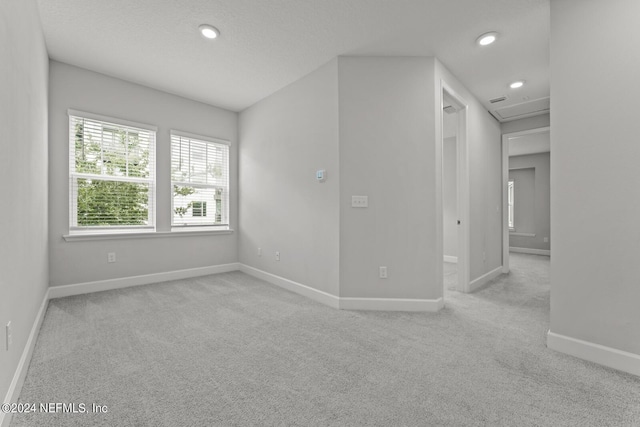 empty room featuring light carpet and a textured ceiling