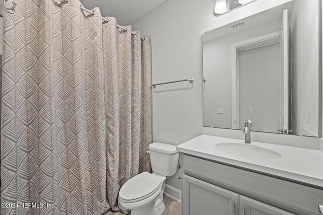 bathroom with toilet, a textured ceiling, and vanity