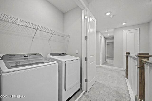 laundry room with light colored carpet and separate washer and dryer