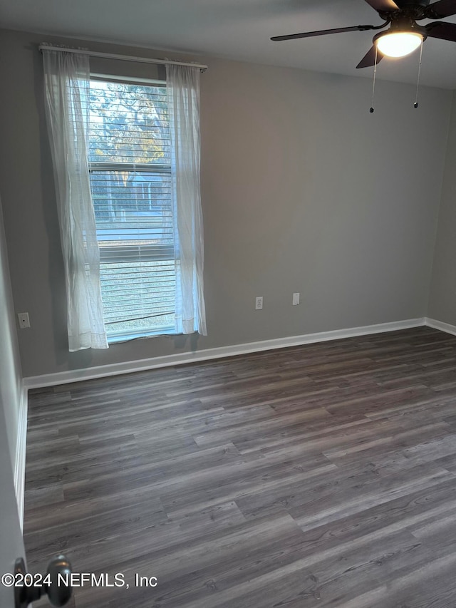 unfurnished room with dark hardwood / wood-style flooring and ceiling fan