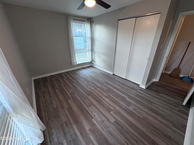 unfurnished bedroom with dark hardwood / wood-style flooring, a closet, and ceiling fan