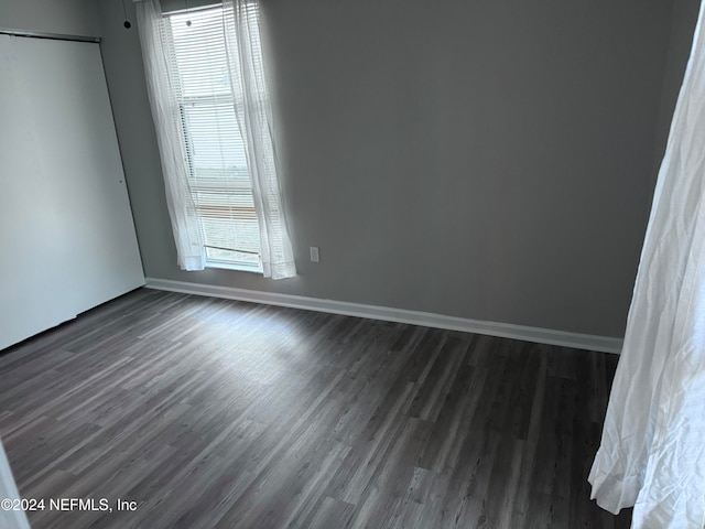 unfurnished room with dark hardwood / wood-style floors