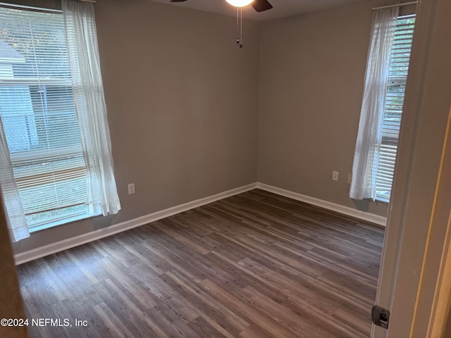 empty room with ceiling fan and dark hardwood / wood-style flooring