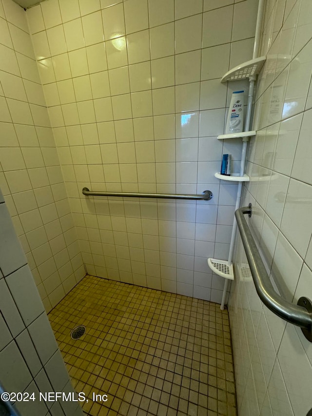 bathroom featuring tile patterned floors, tile walls, and tiled shower