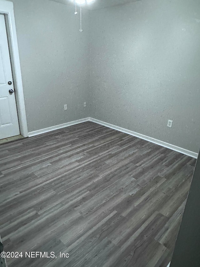 empty room with dark hardwood / wood-style flooring