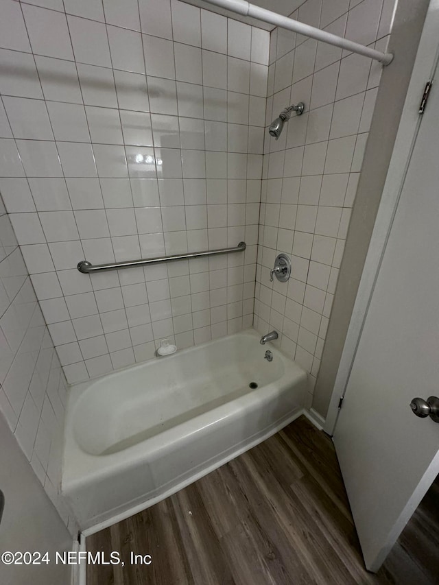 bathroom with tiled shower / bath combo and hardwood / wood-style flooring