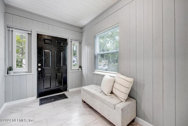 foyer entrance with wooden walls