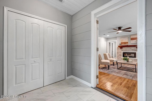 interior space featuring light hardwood / wood-style floors, ceiling fan, and a fireplace