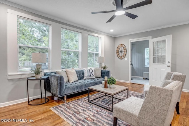 living room with hardwood / wood-style flooring, ornamental molding, and ceiling fan