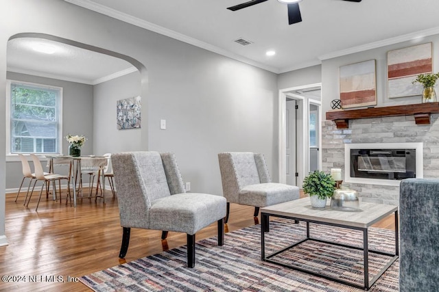 living room with crown molding, ceiling fan, and wood-type flooring