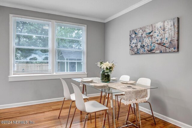 dining room with ornamental molding and wood-type flooring