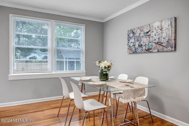 dining area with hardwood / wood-style flooring and ornamental molding