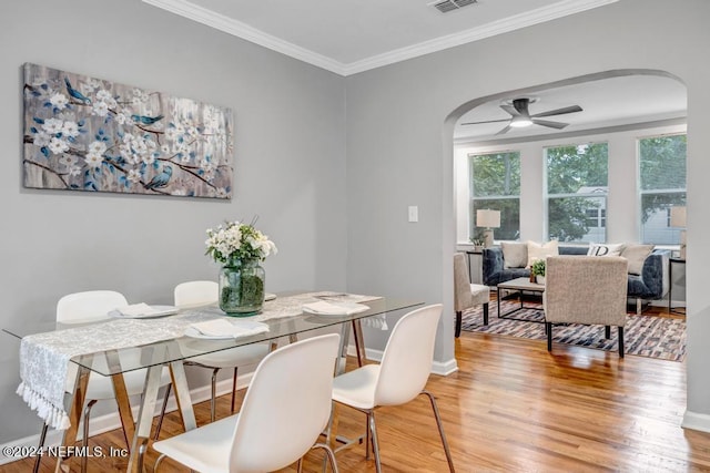 dining area featuring ceiling fan, ornamental molding, and wood-type flooring