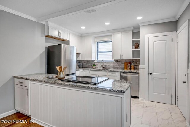 kitchen with white cabinetry, ornamental molding, appliances with stainless steel finishes, and sink