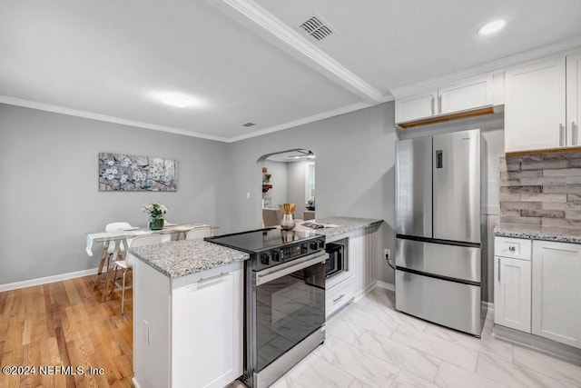 kitchen featuring stainless steel refrigerator, white cabinetry, electric stove, and light stone countertops