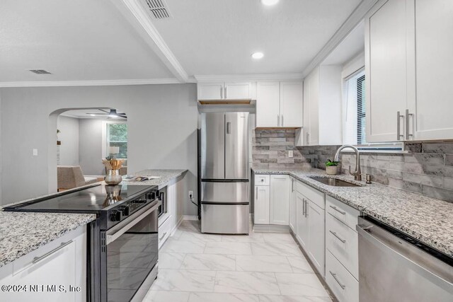 kitchen with sink, stainless steel appliances, light tile patterned flooring, and light stone countertops