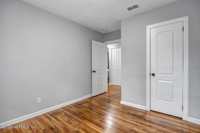 unfurnished bedroom with hardwood / wood-style flooring