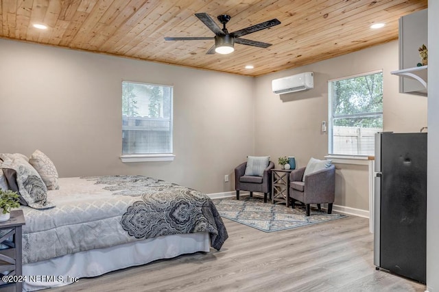 bedroom featuring ceiling fan, a wall unit AC, wood ceiling, black fridge, and light hardwood / wood-style floors