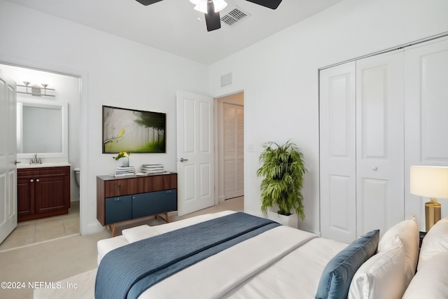 carpeted bedroom featuring sink, a closet, ceiling fan, and ensuite bathroom