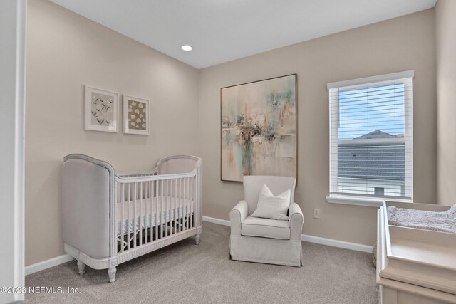 carpeted bedroom with a crib, baseboards, and recessed lighting