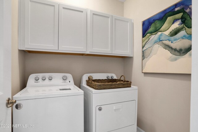 washroom with cabinets and washing machine and dryer