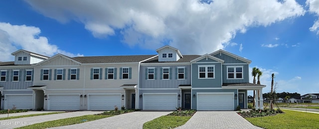 view of property with a garage and a front yard