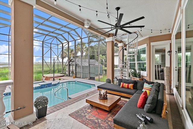 pool featuring glass enclosure, a jacuzzi, ceiling fan, and a patio