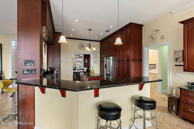 kitchen with ornamental molding, a breakfast bar, and high quality fridge