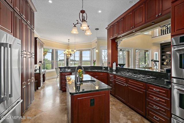 kitchen with reddish brown cabinets, high quality fridge, a chandelier, a sink, and black gas stovetop