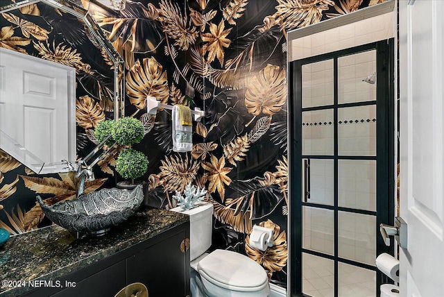 bathroom featuring toilet, vanity, and wallpapered walls