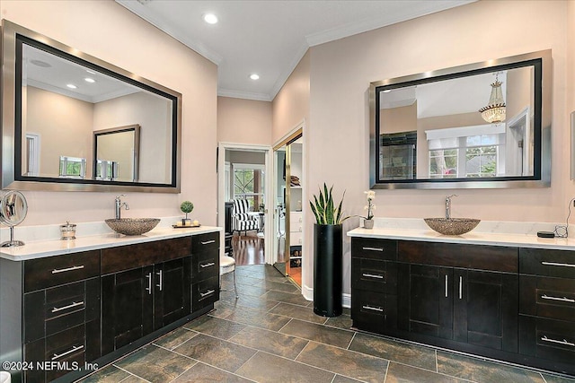 full bath with two vanities, a sink, and crown molding