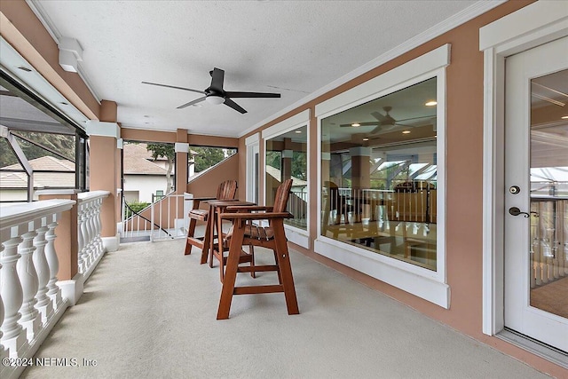 sunroom / solarium featuring a ceiling fan